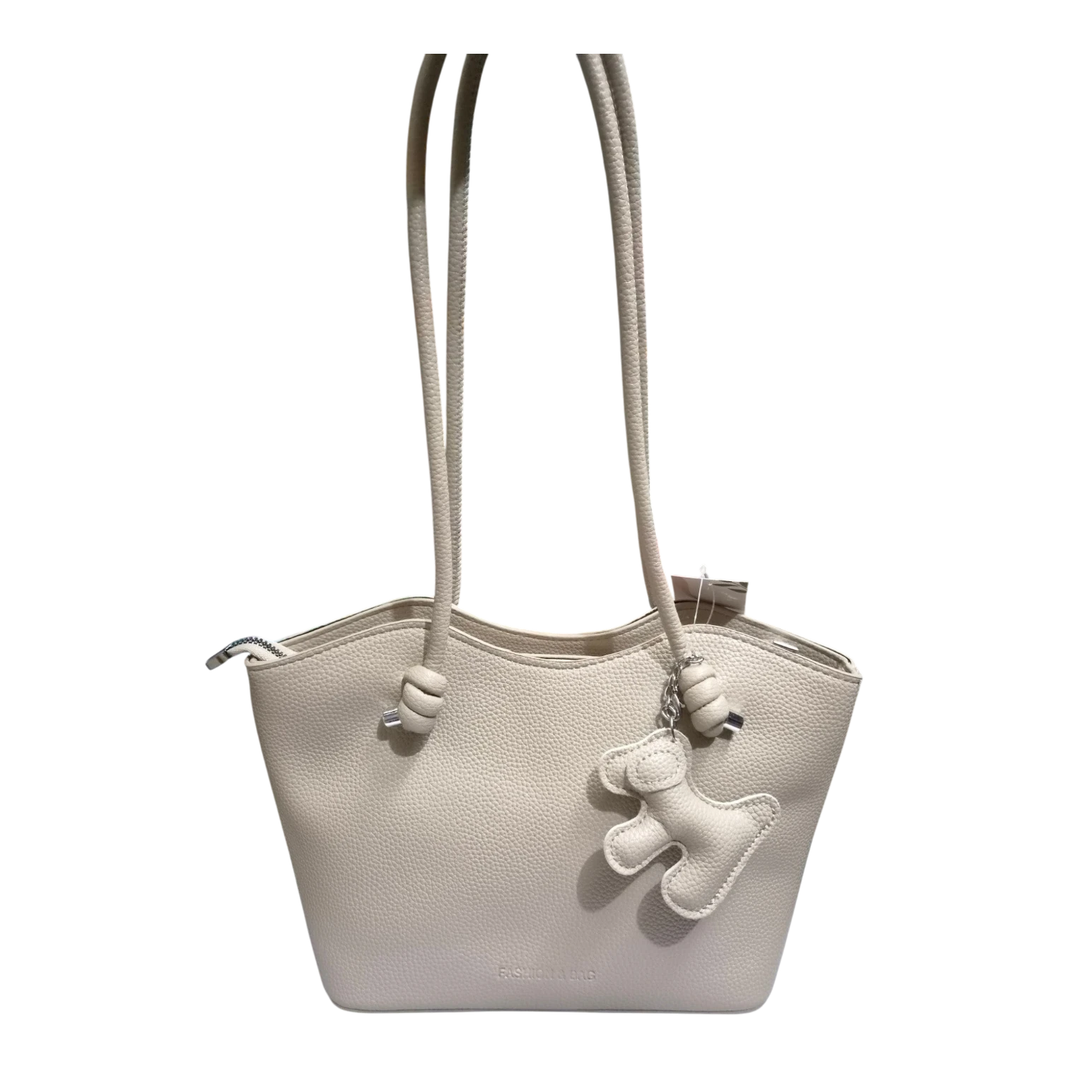 Sheonn beige pebble-textured faux leather tote bag with long shoulder straps and a playful dog-shaped charm.