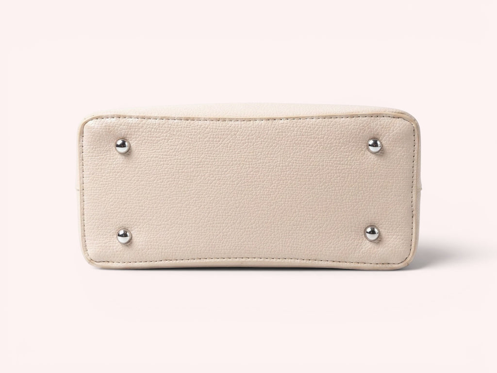 Sheonn beige textured faux leather handbag base with four protective silver-tone metal feet on a white background.