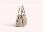 Sheonn beige textured faux leather structured top handle handbag with silver-tone hardware on a white background.