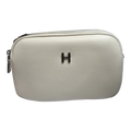 Sheonn cream textured faux leather minimalist crossbody bag with a metallic H logo and zipper closure.