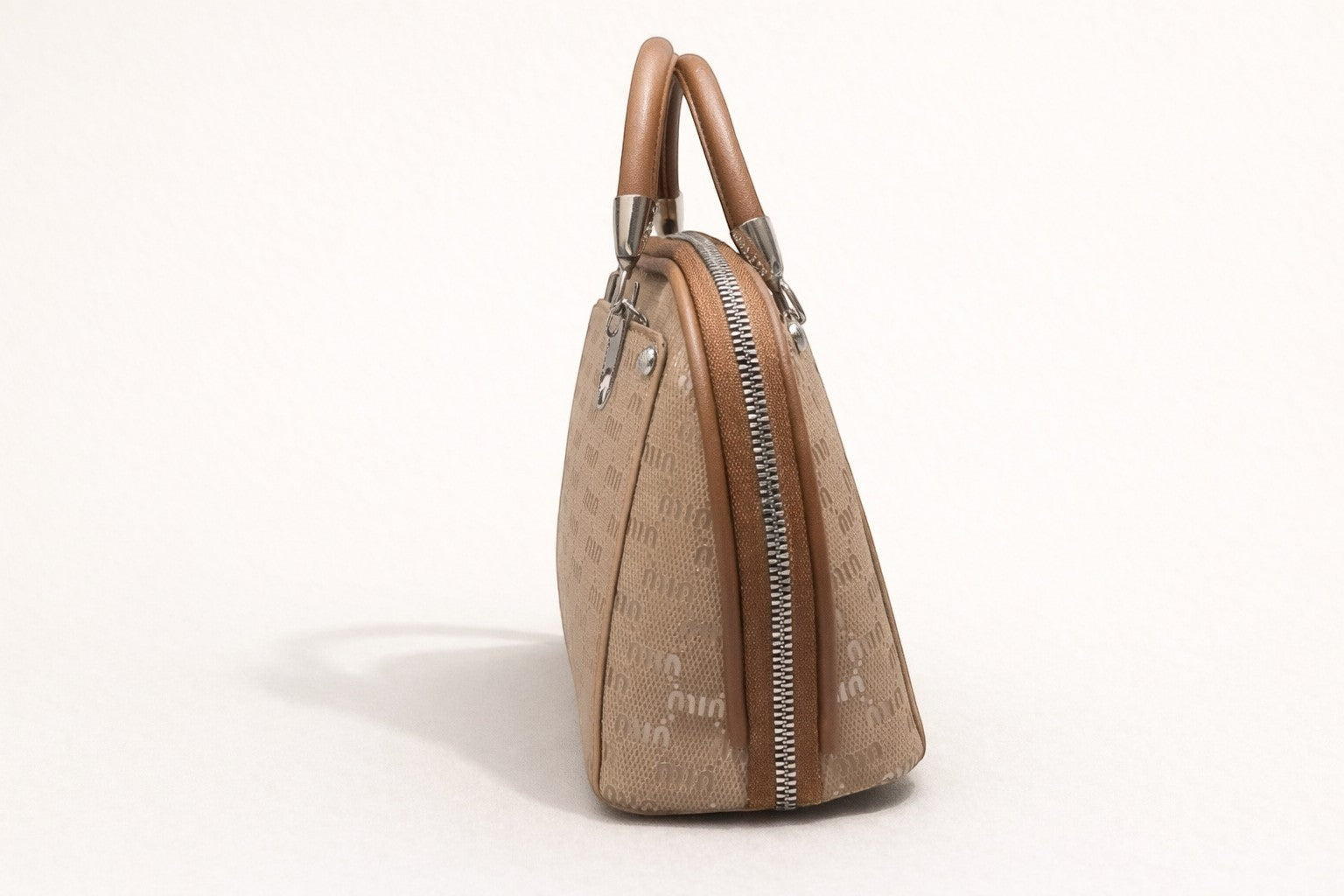 Sheonn structured tan top handle handbag with patterned exterior and polished silver-tone hardware.
