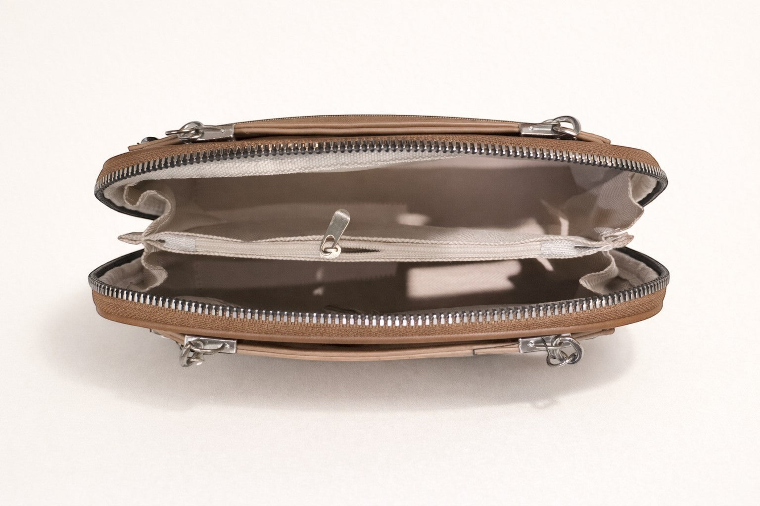 Sheonn tan structured handbag interior with silver zipper, central pocket, and organized compartments.