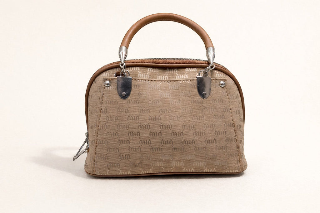 Sheonn structured tan handbag with a patterned exterior, top handle, and polished silver-tone hardware.